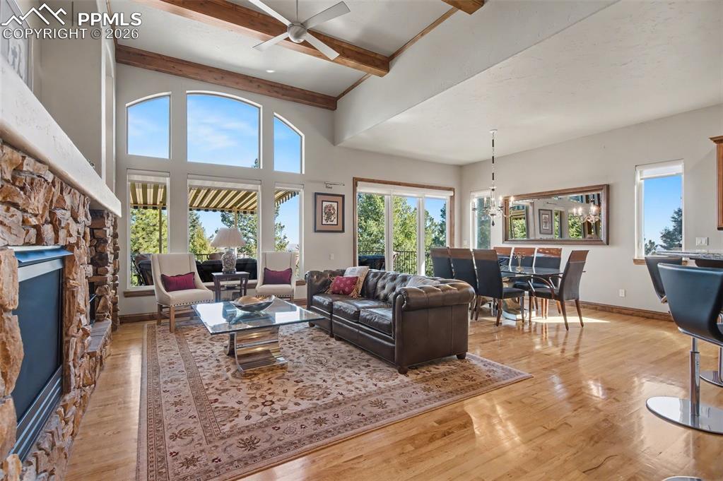 The great room boasts beamed ceilings and towering windows that beautifully frame the surrounding views