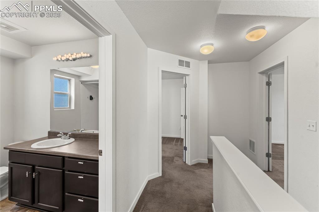 Corridor with dark carpet and a textured ceiling