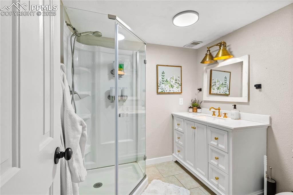 Basement 3/4 bathroom is white and has lots of cabinet storage. 