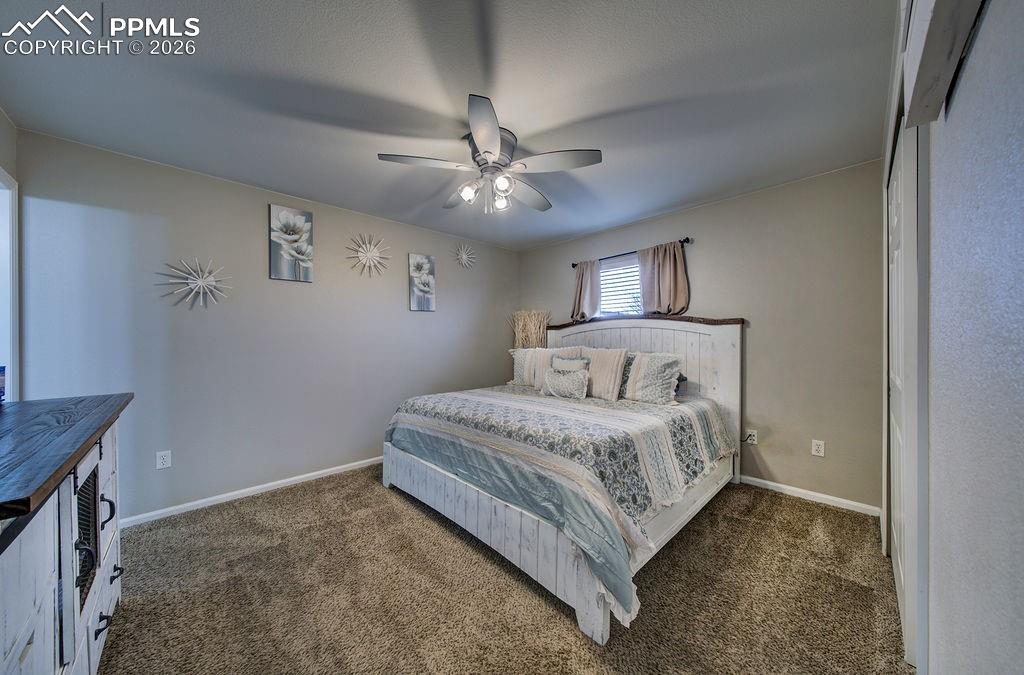 The Primary Bedroom is a private retreat with neutral carpet, a lighted ceiling fan, adjoining bathroom, and closet.