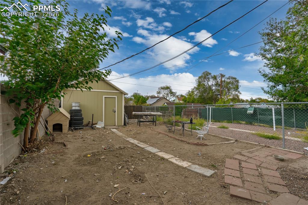 Fenced backyard featuring a storage shed