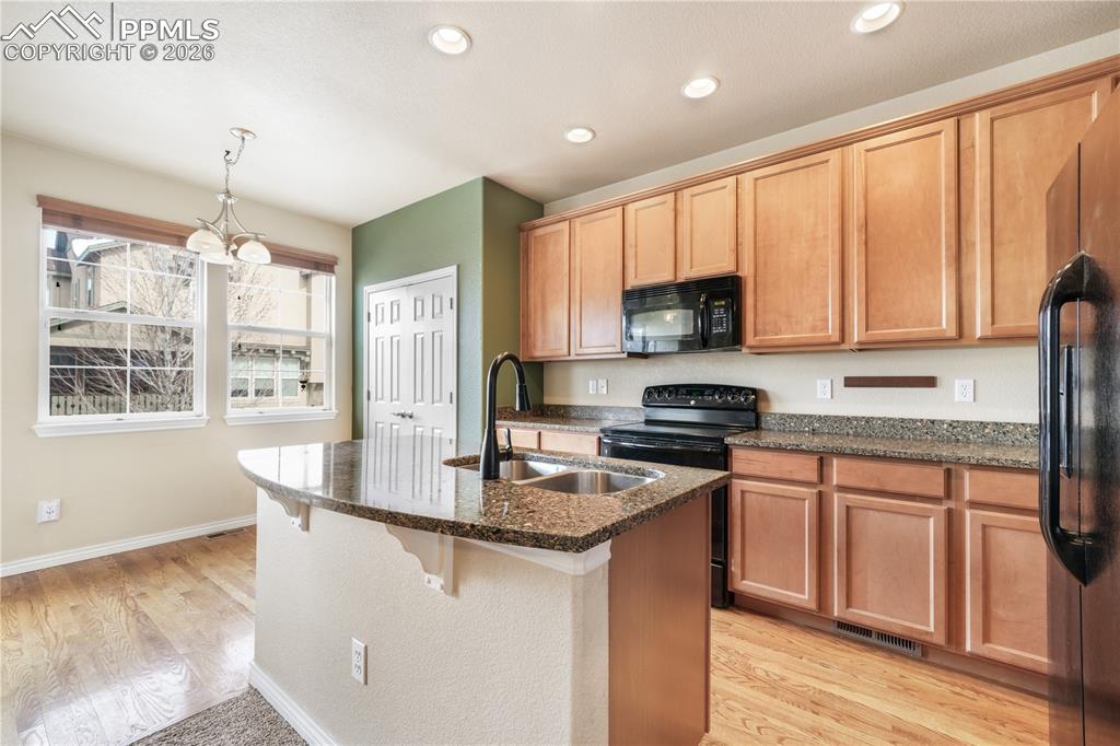 Kitchen with granite countertops, large island, additional breakfast eat in area and covered patio access