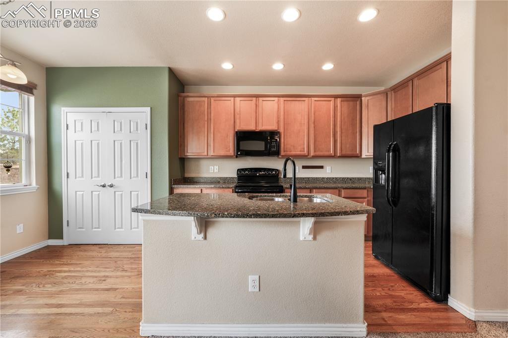 Kitchen with granite countertops, large island, additional breakfast eat in area and covered patio access