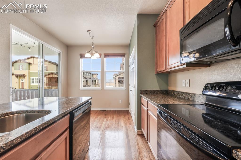 Kitchen with granite countertops, large island, additional breakfast eat in area and covered patio access