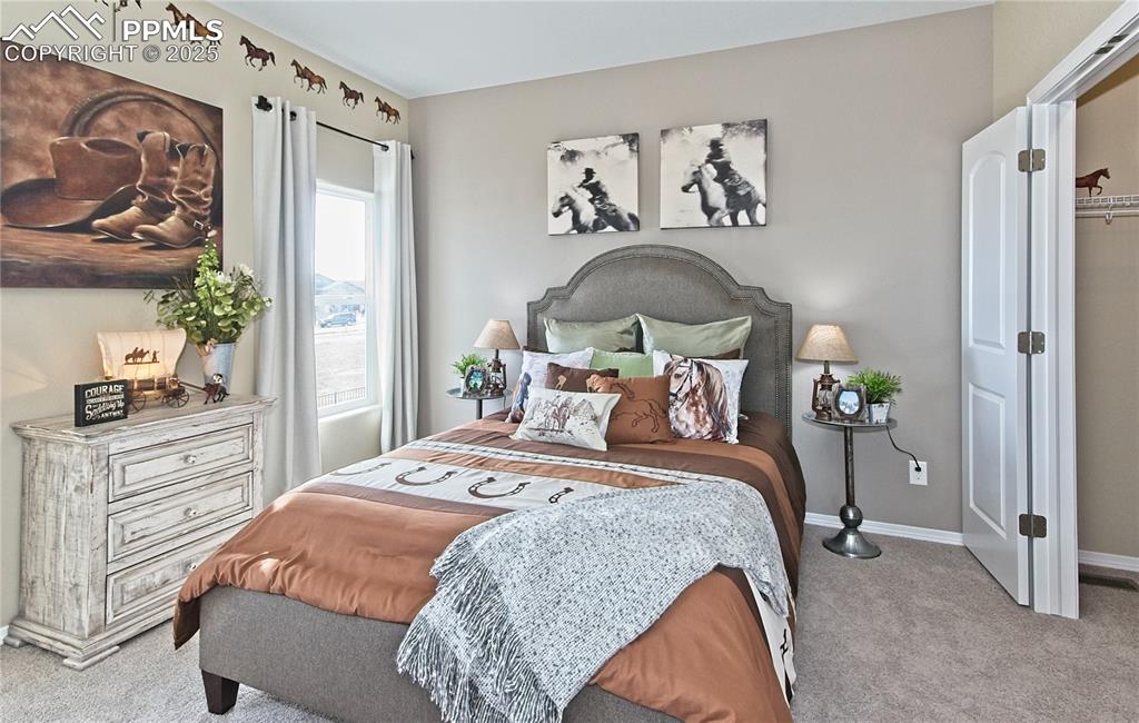 Bedroom with light colored carpet and baseboards