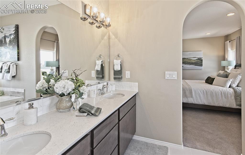 Full bathroom featuring double vanity, ensuite bathroom, a bath, plenty of natural light, and recessed lighting