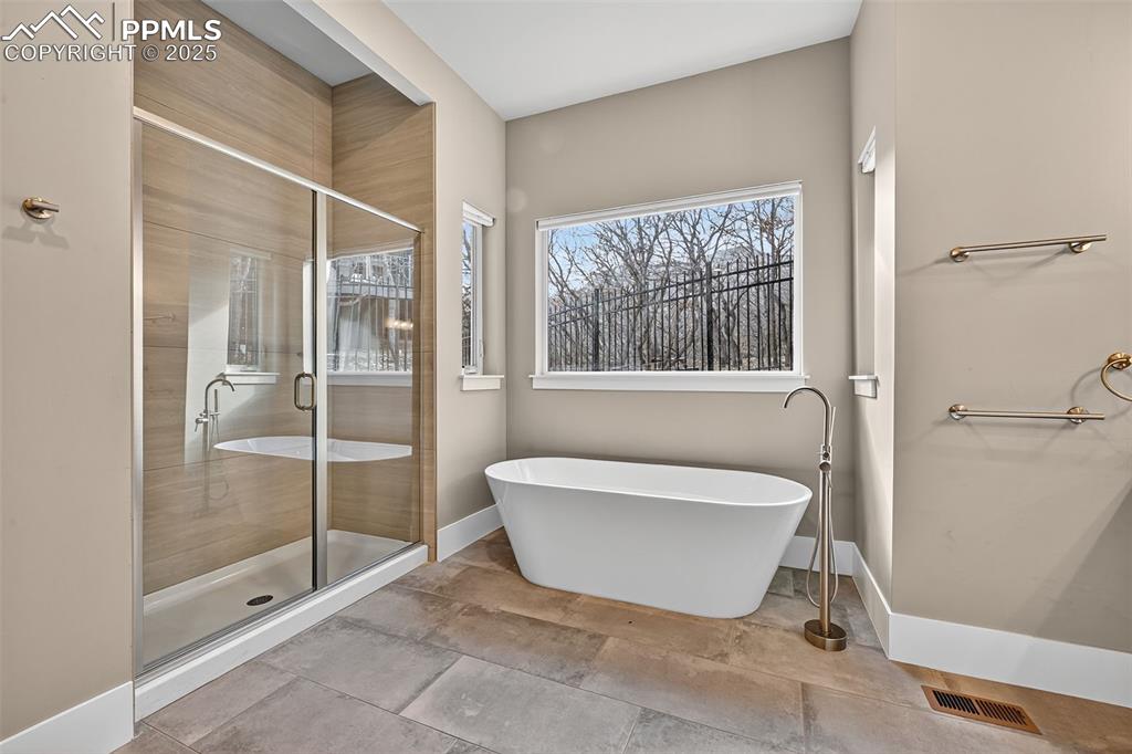 Bathroom featuring a stall shower and a freestanding bath