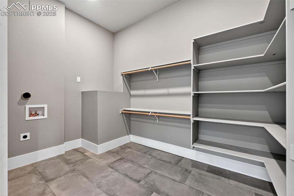 Laundry room with electric dryer hookup, hookup for a washing machine, and concrete floors