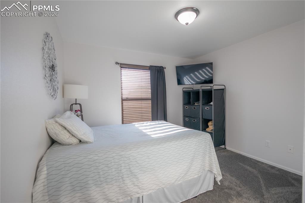 Kitchen featuring arched walkways, white cabinetry, a peninsula, a ceiling fan, and lofted ceiling