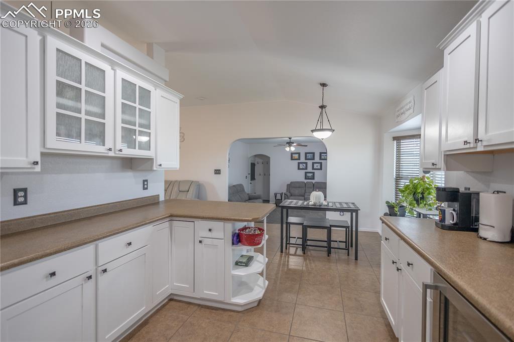 Kitchen featuring appliances with stainless steel finishes, white cabinets, vaulted ceiling, and recessed lighting