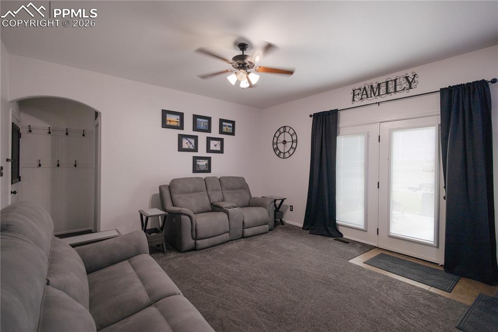 Carpeted living room with ceiling fan