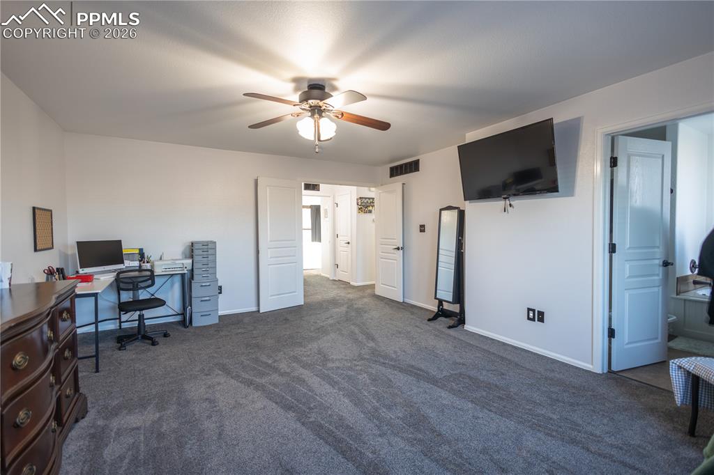 Carpeted living room with ceiling fan