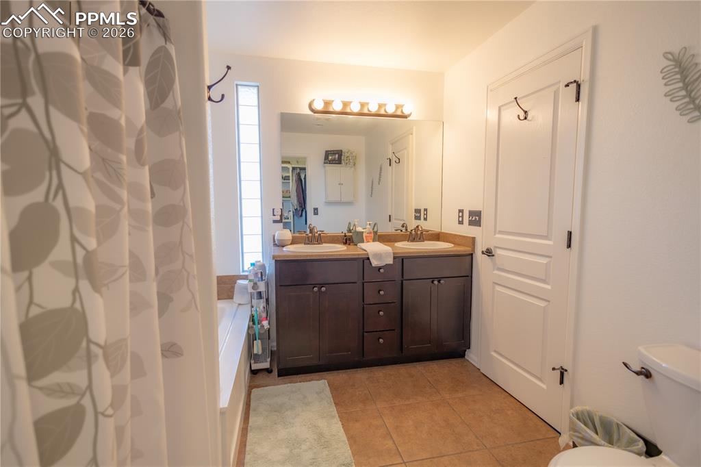 Bathroom featuring double vanity and light tile patterned floors