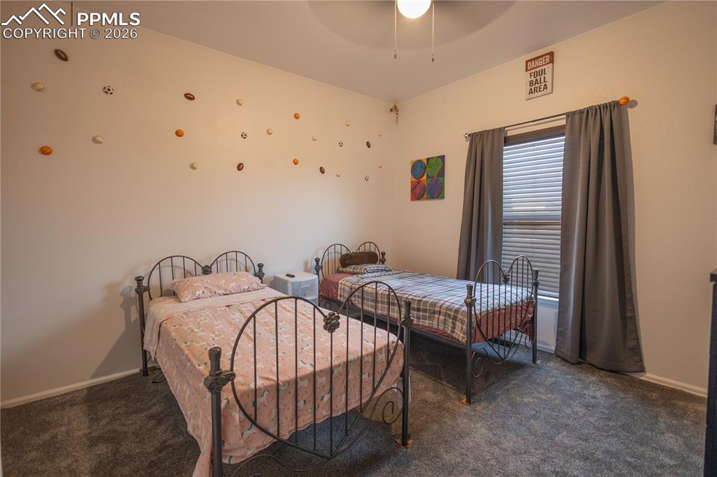 Bedroom featuring dark carpet and a ceiling fan