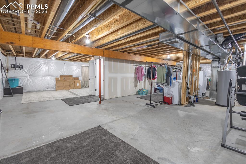 Unfinished basement featuring water heater and heating unit