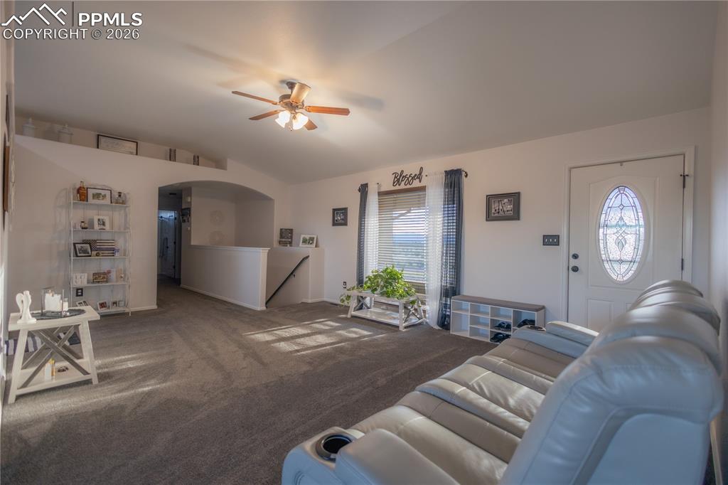 Kitchen with appliances with stainless steel finishes, a breakfast bar area, white cabinets, pendant lighting, and a peninsula