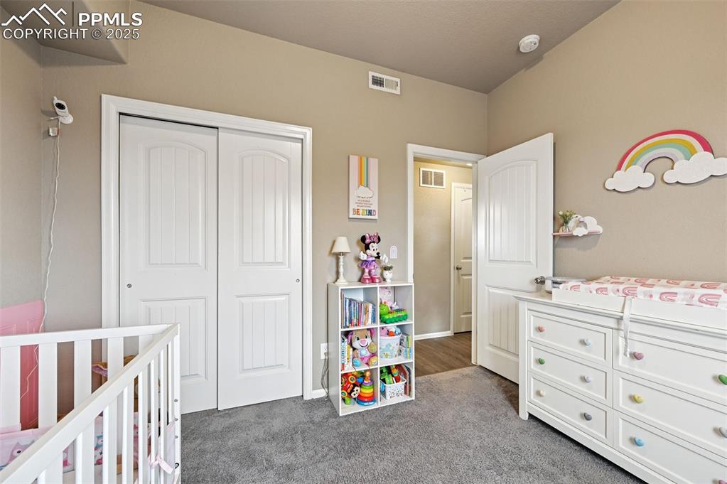 Bedroom featuring dark colored carpet and a closet