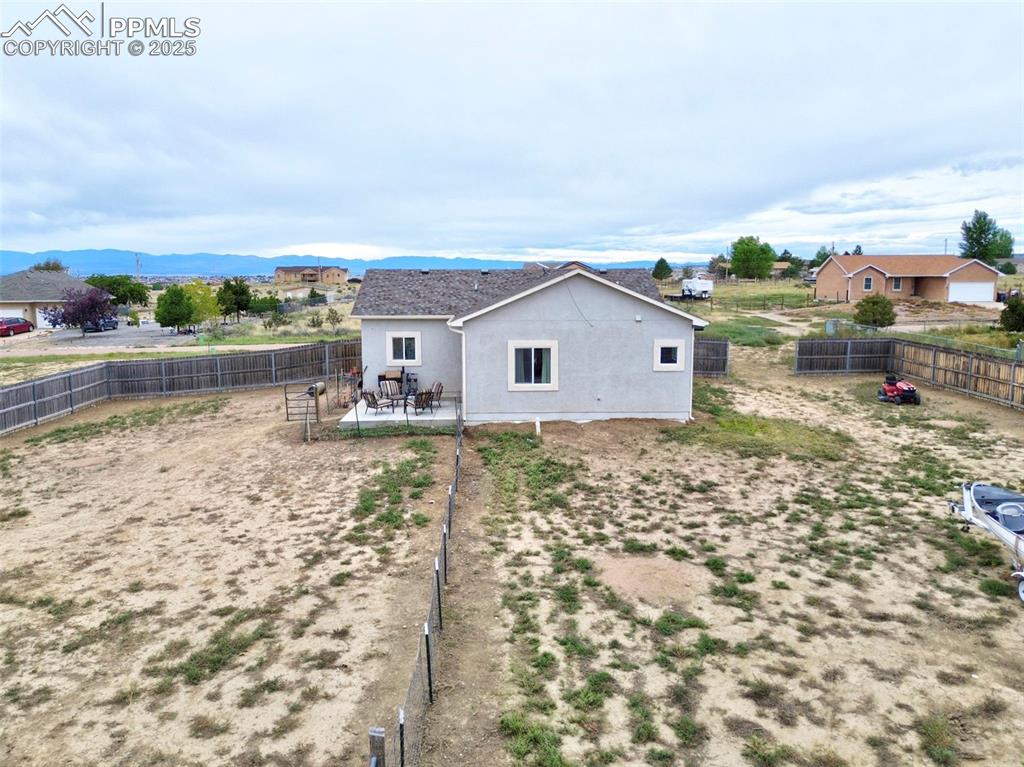 Rear view of property with a patio area, stucco siding, a fenced backyard, and a mountain view