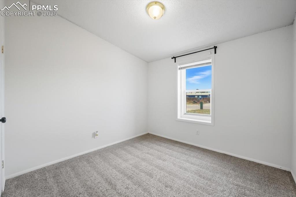 Empty room featuring carpet flooring and baseboards