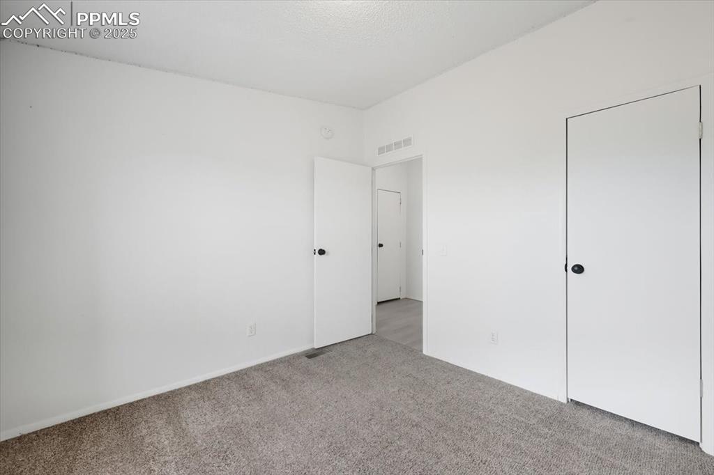 Unfurnished bedroom featuring carpet flooring and baseboards