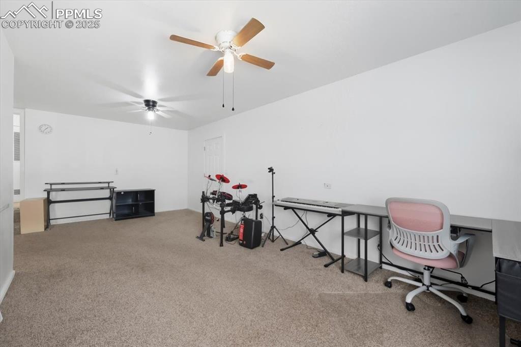 Home office featuring carpet flooring and ceiling fan
