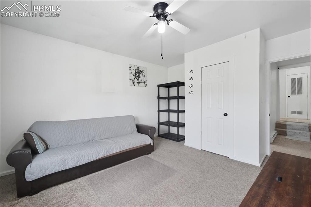 Sitting room with carpet floors, a ceiling fan, and baseboard heating