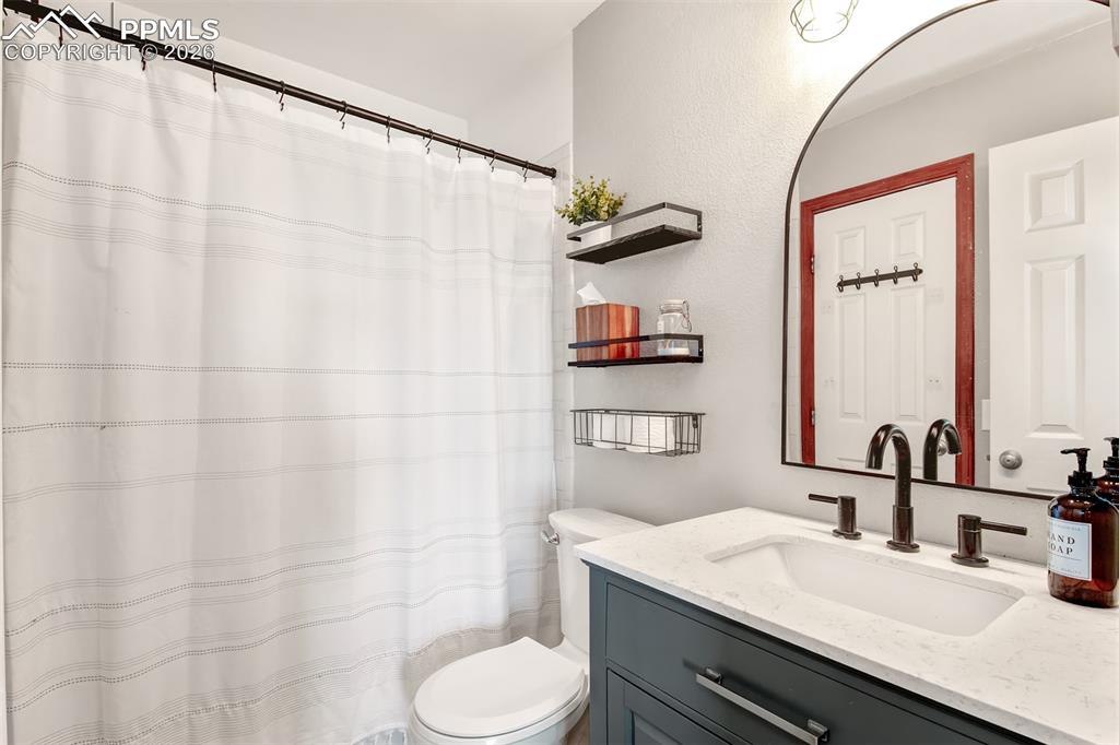 Full primary bathroom with quartz vanity and tub/shower combo