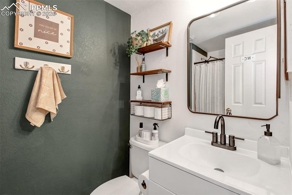 Lower level 3/4 bathroom with porcelain vanity and free standing shower