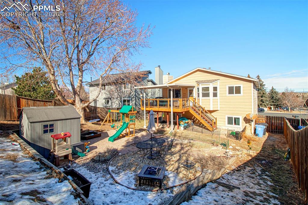 Large fenced backyard with storage shed is slightly sloped to add more privacy