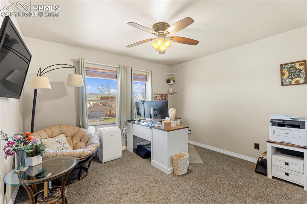 Office area with light carpet and ceiling fan