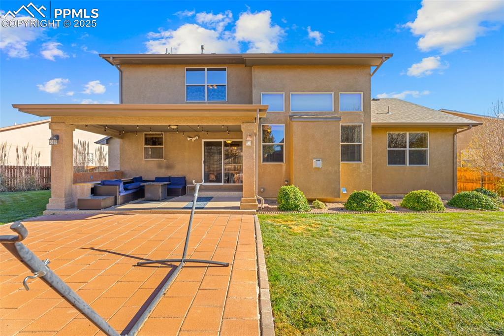 Back of property featuring an outdoor hangout area, stucco siding, and a patio