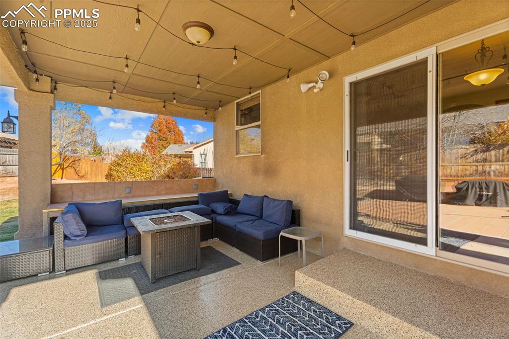 View of patio with an outdoor living space with a fire pit