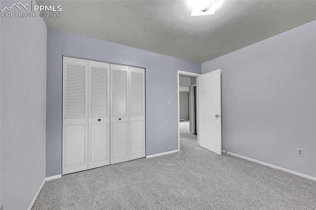 Unfurnished bedroom featuring carpet and a closet