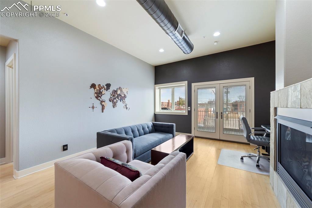 Living room with hardwood floors, recessed lighting, french doors, and a desk