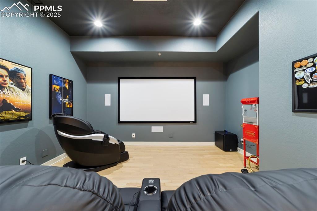 Theater room with hardwood floors and recessed lighting