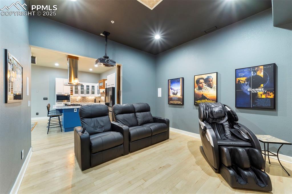 Theater room with hardwood floors and recessed lighting
