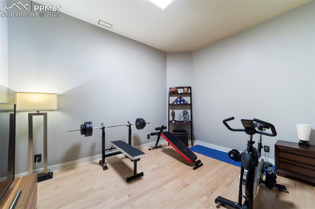 Large bedroom is currently being used as a gym featuring hardwood floors