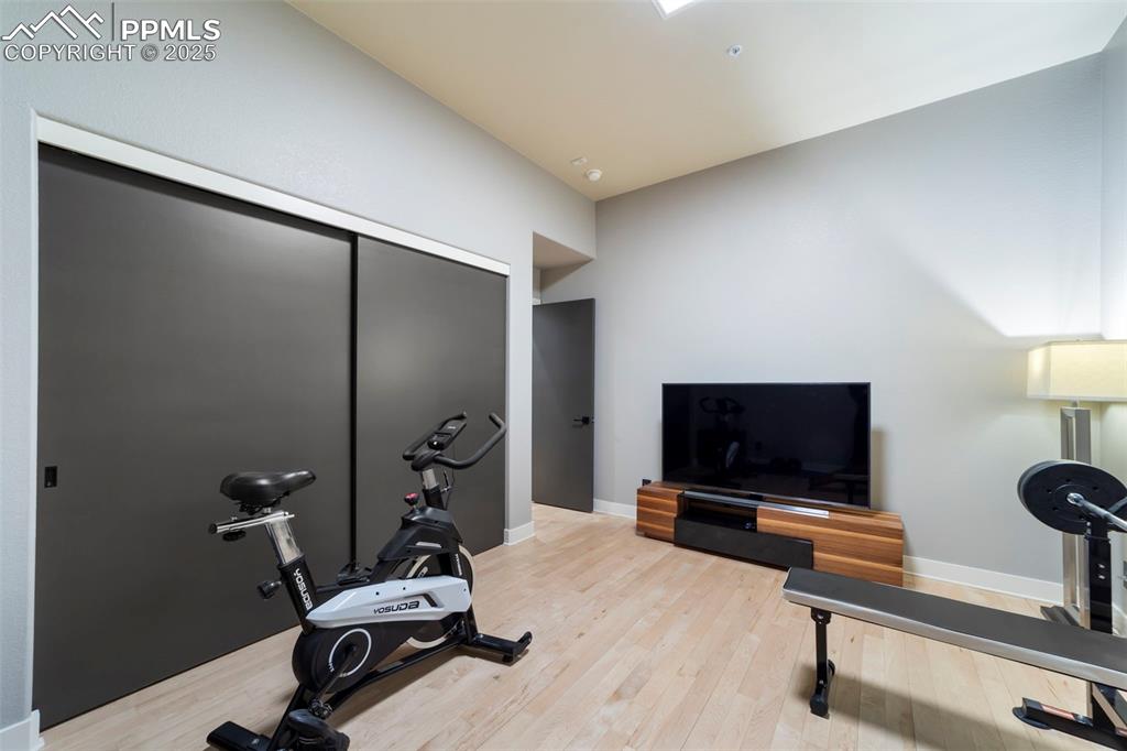 Large bedroom is currently being used as a gym featuring hardwood floors