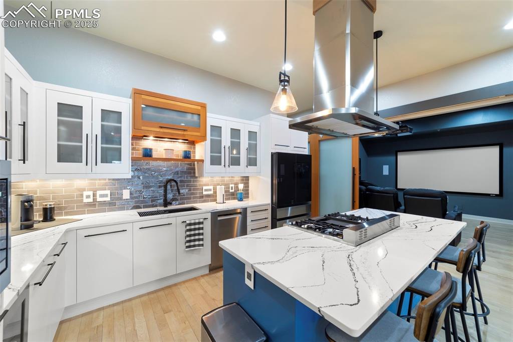 Kitchen with white cabinetry, decorative light fixtures, a kitchen island, quartz counters, and open shelves