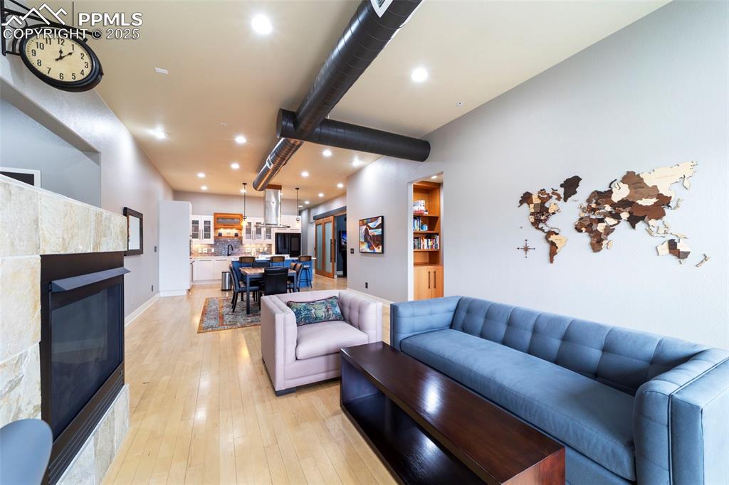 Living area with a tile fireplace, recessed lighting, and hardwood floors.