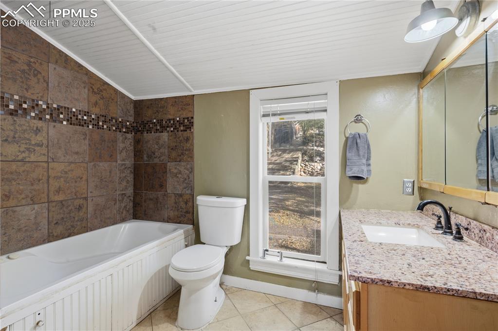 Full bathroom with vanity, light tile patterned floors, and shower / bathtub combination