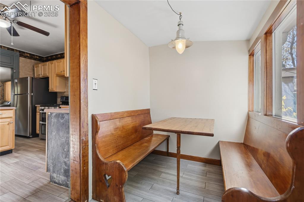 Dining space with wood finish floors and ceiling fan