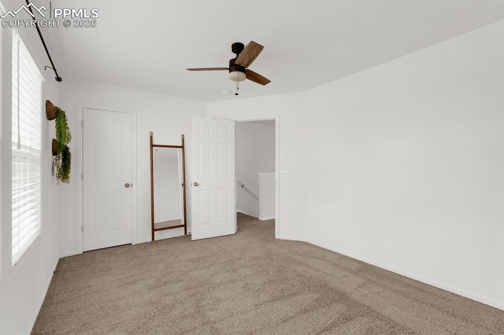 Bedroom featuring light colored carpet and ceiling fan