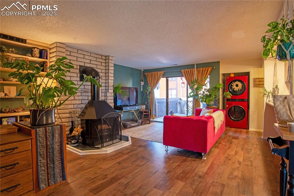 Living area featuring LVP flooring throughout, and in-unit stacked washer/dryer 