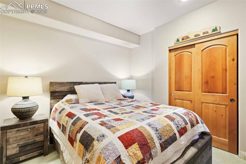 Bedroom featuring light carpet and a closet