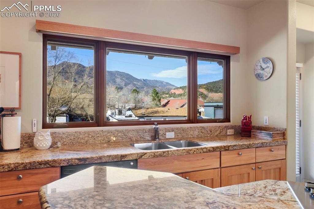 Kitchen featuring a mountain view, light stone counters, and stainless steel cooktop