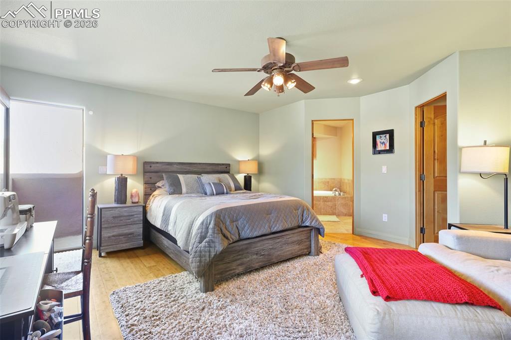 Bedroom featuring ensuite bath, light wood-style floors, ceiling fan, and recessed lighting