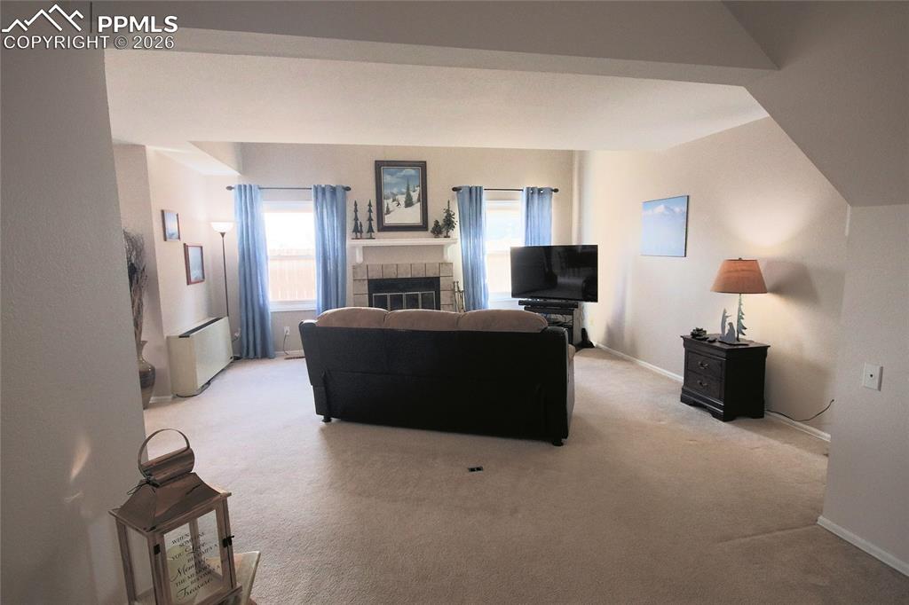 Entry with living room. There is an electrical receptacle in the floor behind the couch. 