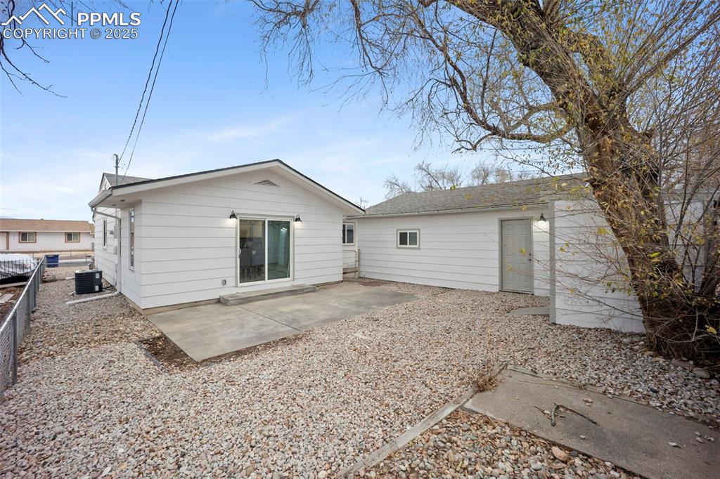 Rear view of fenced property featuring a patio, storage shed