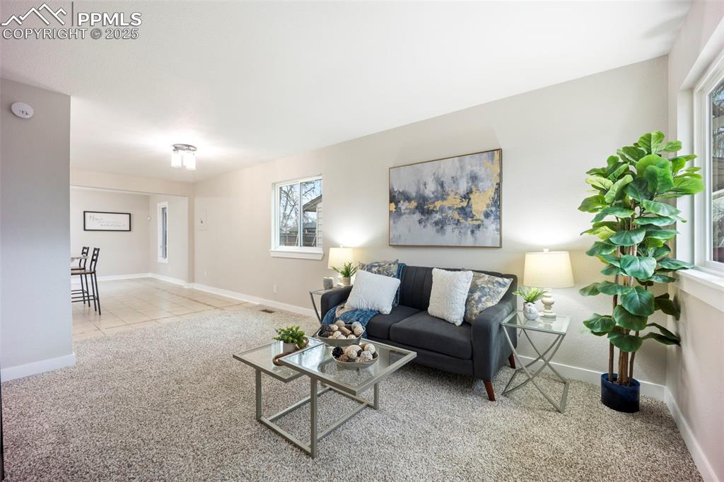 Living room featuring baseboards and light carpet